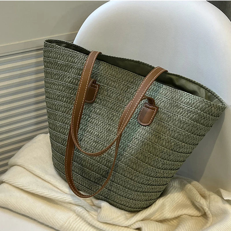 Bolsa trançada de palha verde com alça de couro da Loja Morela, ideal para looks de verão e estilo casual