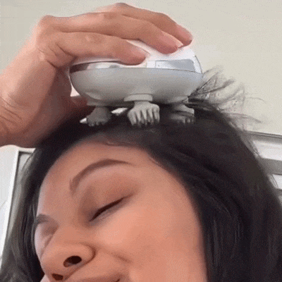 Jovem usando o massageador de couro cabeludo de forma tranquila e relaxada. Morela