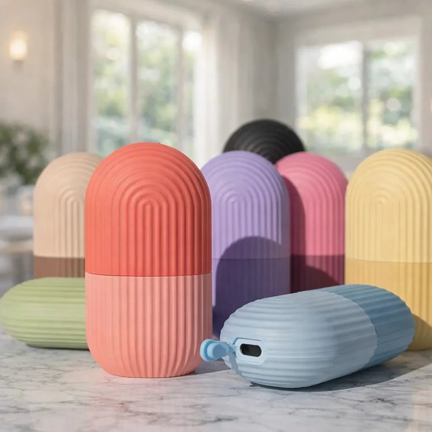 Diversos massageadores faciais de silicone em tons pastéis organizados para exibição de cores Loja Morela