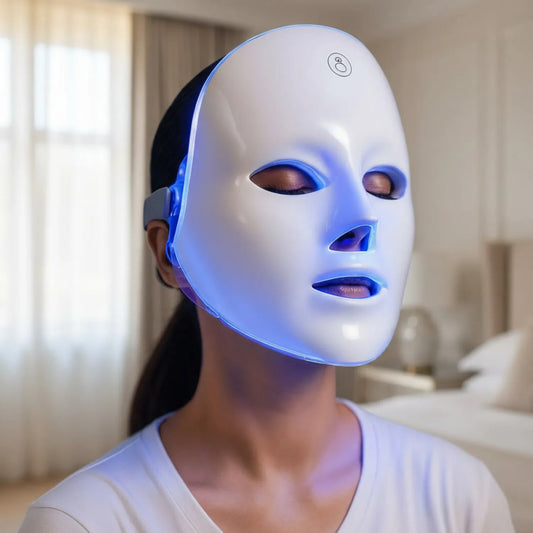 Mulher utilizando a máscara de LED com a luz azul ativada para cuidados faciais Loja Morela