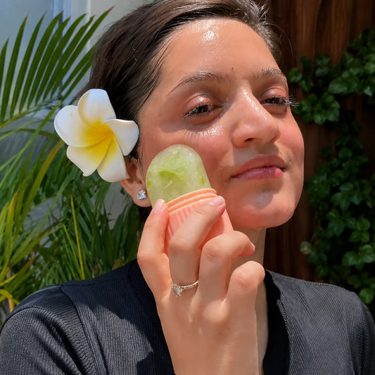 Mulher aplicando o massageador facial de gelo em silicone no rosto para crioterapia e cuidados com a pele Loja Morela