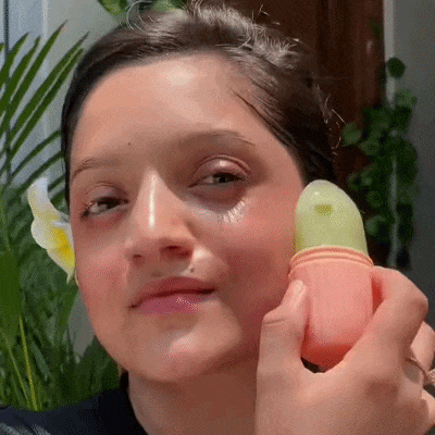 Mulher aplicando o massageador de gelo no rosto para redução de inchaço e vermelhidão Loja Morela