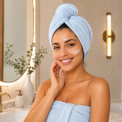 Mulher sorrindo utilizando touca de cabelo em microfibra azul após o banho Loja Morela