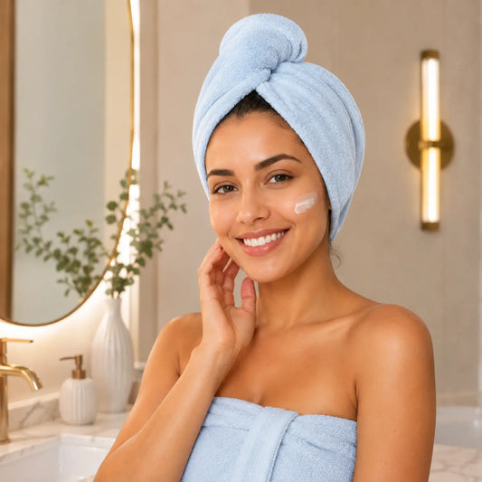 Mulher sorrindo utilizando touca de cabelo em microfibra azul após o banho Loja Morela